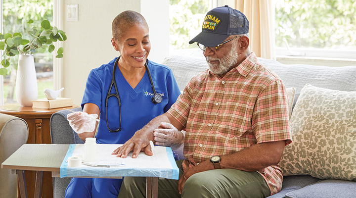 A CenterWell Home Health clinician treating a patient's wound in his home